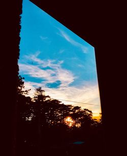 Low angle view of silhouette trees against sky