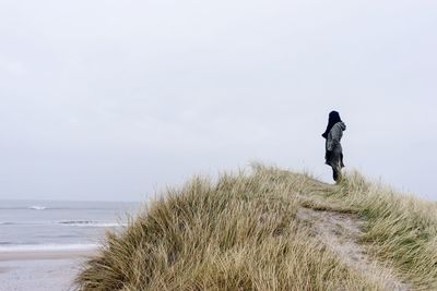 Man on beach against clear sky