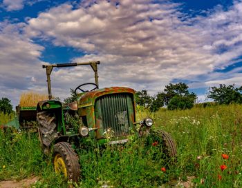 Abandoned tractor on field against sky