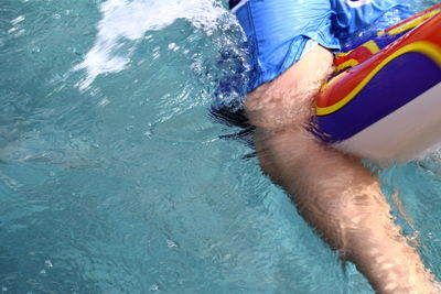 Midsection of person swimming in pool