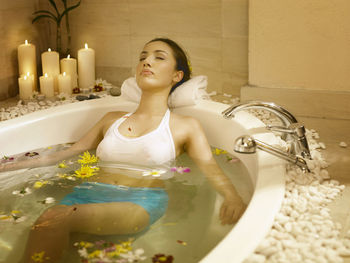 Close-up of young woman relaxing in bathtub at hotel