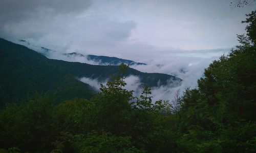 Scenic view of clouds on mountains against sky