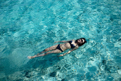 High angle view of woman swimming in a crystal clean ocean 