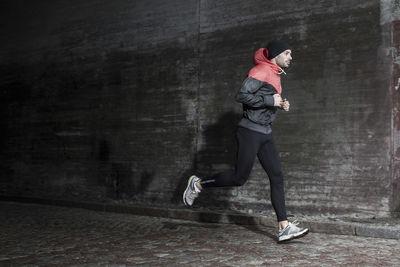 Full length of man jogging on street