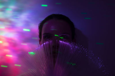 Close-up portrait of woman with illuminated lights