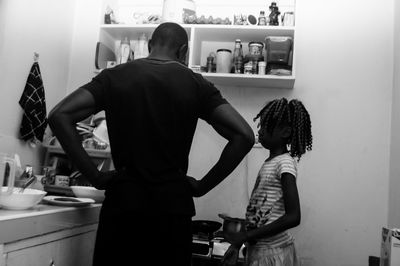 Father with daughter standing in kitchen at home