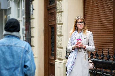 Woman standing by building in city