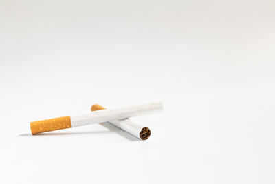 Close-up of cigarette smoking against white background