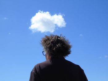 Low angle portrait of man against blue sky