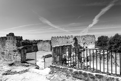 View of old gate against cloudy sky