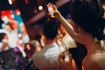 Rear view of a woman drinking glass