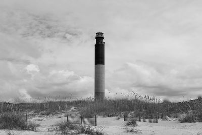 Oak island lighthouse taken from the ocean to include the dunes in black and white.