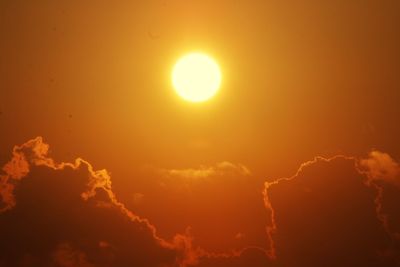 Low angle view of sun in sky during sunset