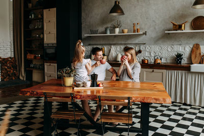 A happy cheerful family with a child is cooking dinner together in the kitchen at home