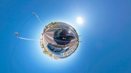 Digital composite image of ferris wheel against blue sky