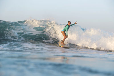 Man surfing in sea against sky