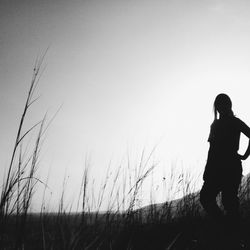 Silhouette of woman standing by tree