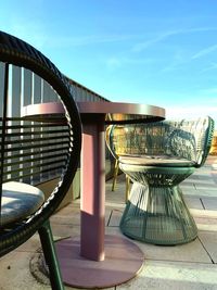 Chairs and table by swimming pool against sky