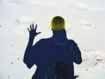 Shadow of man with ball on sand