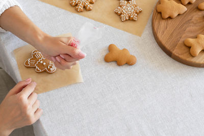 Cropped hand of woman holding heart shape on table