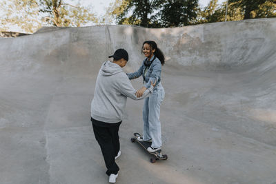 Teenage girl learning how to skate in skate park