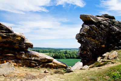 Rock formation by sea against sky