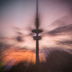 View of communications tower against cloudy sky