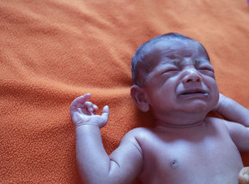 Portrait of shirtless boy lying