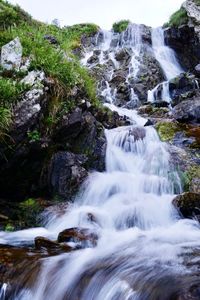 Scenic view of waterfall against sky