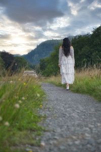 Rear view of woman walking on field