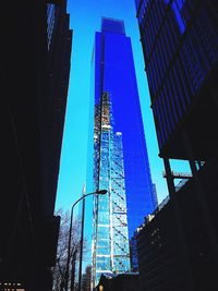 Low angle view of skyscrapers against blue sky