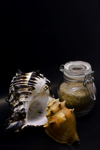 Close-up of jar on table against black background