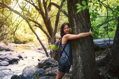 Young woman hugging a tree. she is happy.