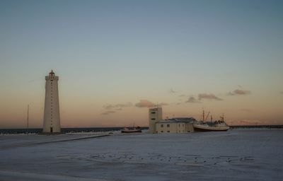 Lighthouse against sky at sunset