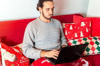 Young man sitting on sofa at home