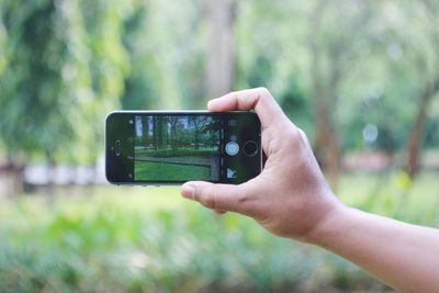 Close-up of hand photographing with mobile phone