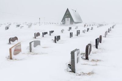 Wooden fence on snow covered field