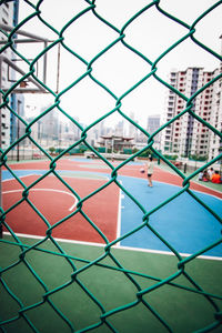 Full frame shot of chainlink fence against buildings