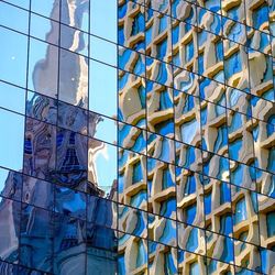 Full frame shot of glass building with reflection in city