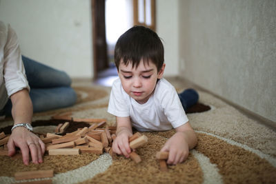 Boy playing on the floor in a wooden designer, lifestyles and soft focus, warm toning