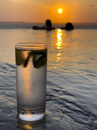 Close-up of water in sea against sunset