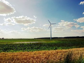 Scenic view of field against cloudy sky