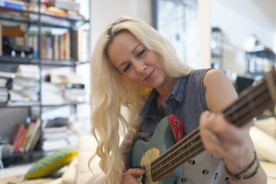 Beautiful young woman playing an electric guitar