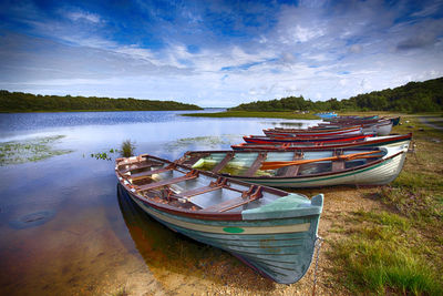 Boat moored on shore against sky