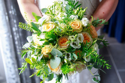 Midsection of woman holding flower bouquet