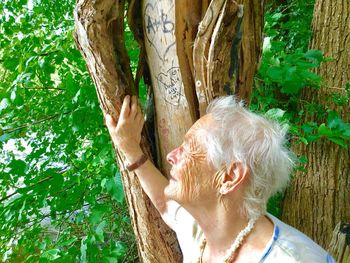 Close-up of woman by tree trunk