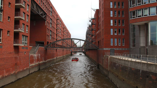 Bridge over canal amidst buildings in city