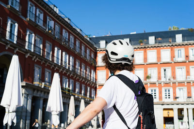 Rear view of woman against buildings in city