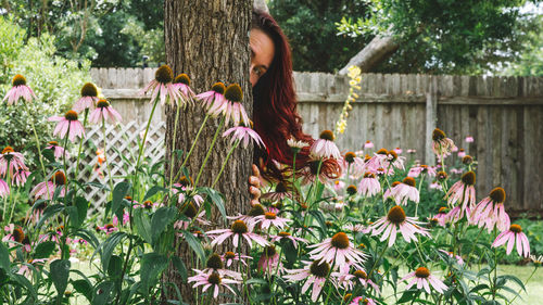 Woman hiding behind tree at park