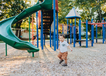 Diverse mixed race toddler boy at playground park having fun making childhood memories